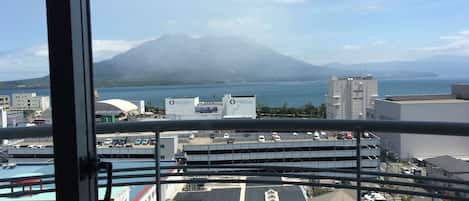A view from a balcony overlooking a cityscape with a mountain in the background.