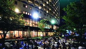 A large hotel with multiple balconies and a well-lit outdoor dining area. - Kagoshima Sun Royal Hotel (Kagoshima)