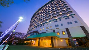 A multi-story hotel with a curved facade, illuminated windows, and a prominent entrance. - Kagoshima Sun Royal Hotel (Kagoshima)