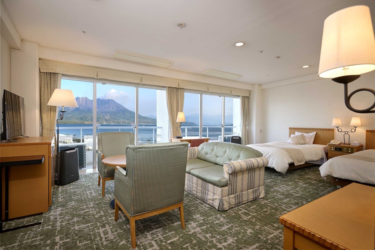 Habitación de hotel con cama, escritorio, silla y vista al mar.