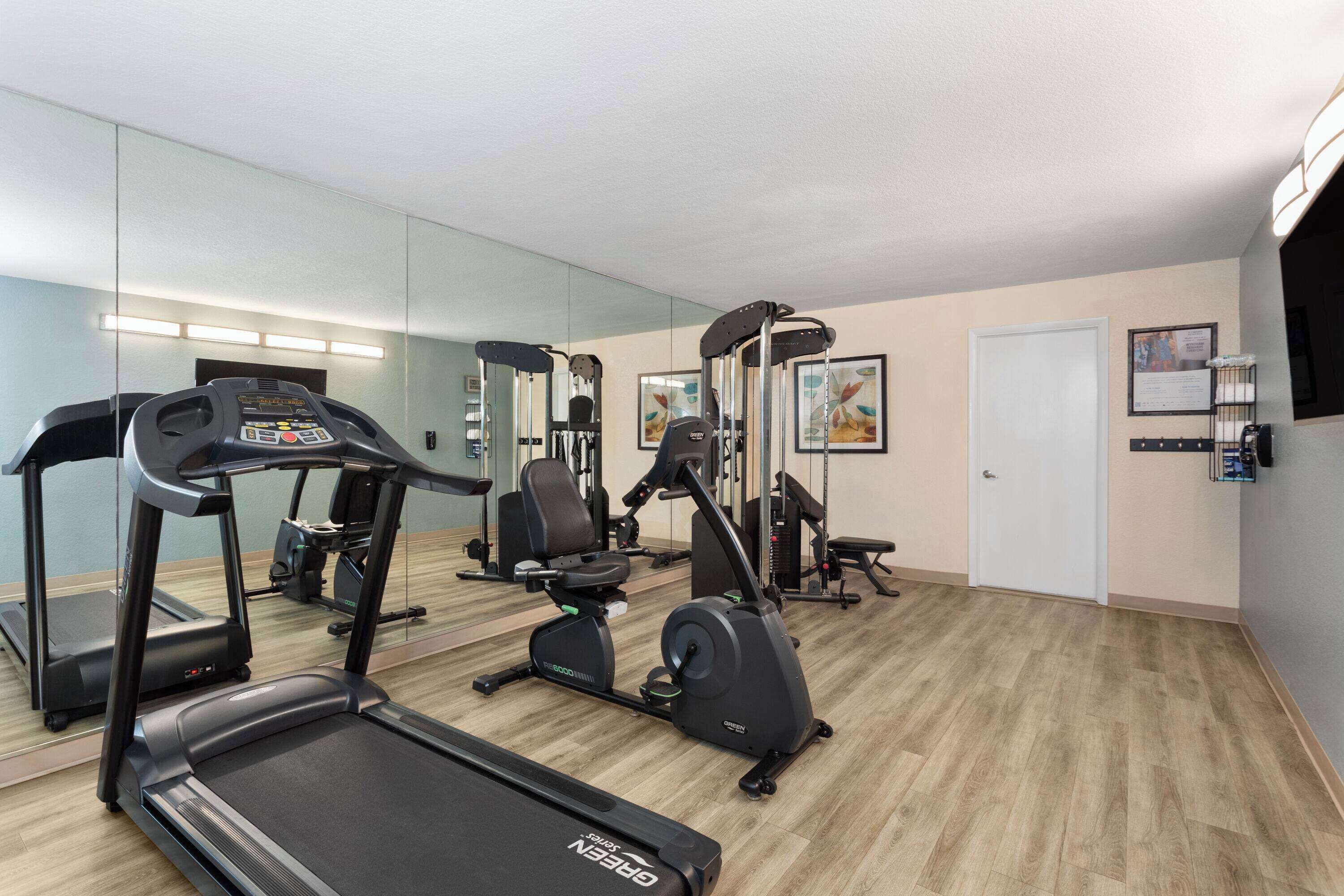 A gym with treadmills, an elliptical, and weight machines.