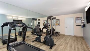 A gym with treadmills, an elliptical, and weight machines.