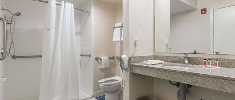 Une salle de bain équipée d’une douche, de toilettes, d’un lavabo et d’un miroir.