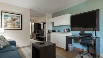 Een moderne woonkamer met een bank, salontafel en televisie.