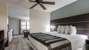 A hotel room with a large bed, a ceiling fan, a desk, and a window. - Baymont by Wyndham Punta Gorda/Port Charlotte (Punta Gorda)