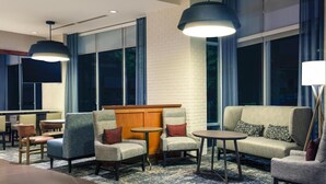 A hotel lobby with seating areas, a wooden partition, and large windows. - Hyatt Place Raleigh/Cary (Raleigh)