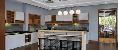 Een moderne keuken met witte kasten, een backsplash van visgraatmozaïek en een centraal eiland met krukken.