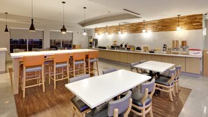 A modern kitchen with wooden accents, a central island, and bar-style seating.