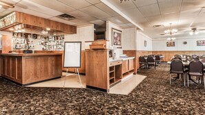 A conference room with a bar area, wooden paneling, and a carpeted floor.