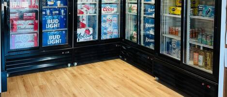 Mostrador refrigerado con diversas marcas de cerveza y bebidas.