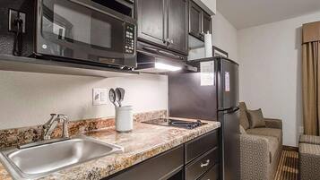 Escritorio, cortinas blackout y tabla de planchar con plancha