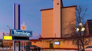 A Travelodge hotel with a large sign, a parking area, and a snow-covered ground. - Travelodge by Wyndham North Battleford (North Battleford)