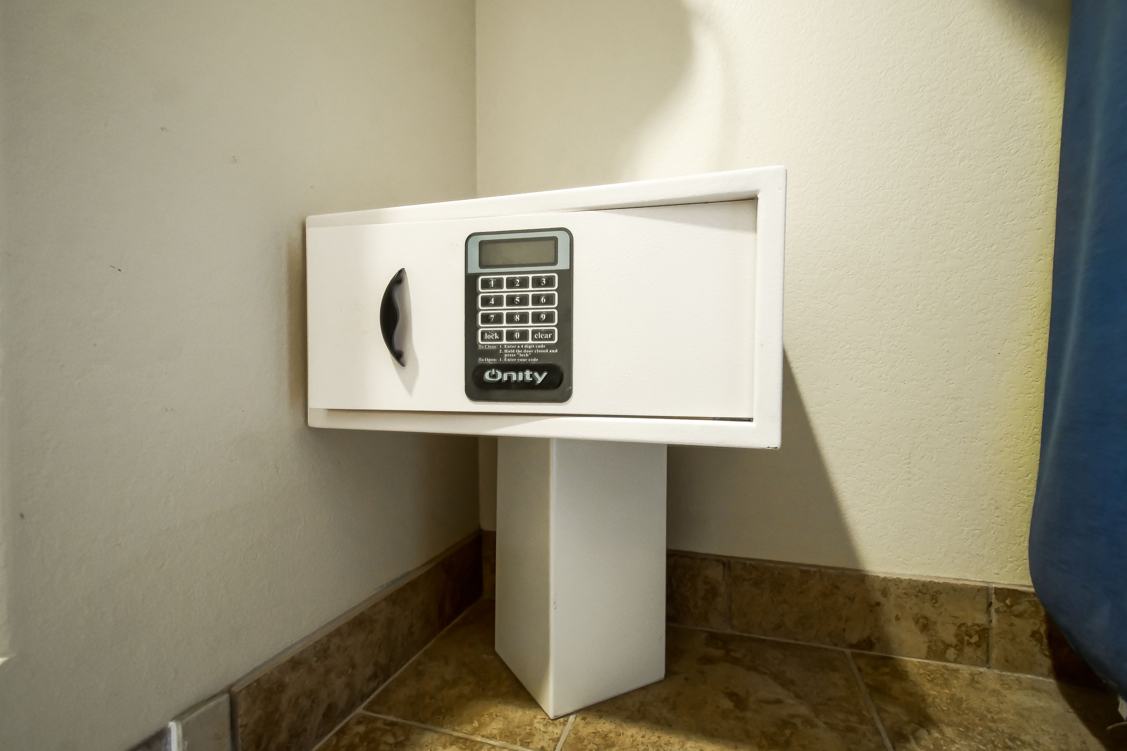 A white, standalone, wall-mounted, digital keypad lock.