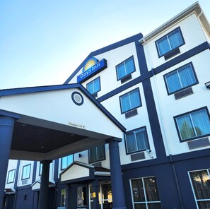 Un hotel con un cartel visible que dice "Days Inn by Wyndham" y un letrero que indica "Altura Libre 4.27 metros".