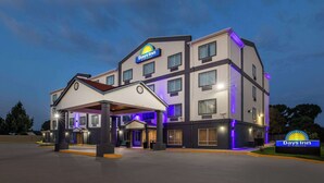 Un hotel Days Inn con diseño moderno, que cuenta con varios pisos y una zona de entrada cubierta.