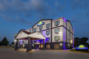 Un hotel Days Inn con diseño moderno, que cuenta con varios pisos y una zona de entrada cubierta.