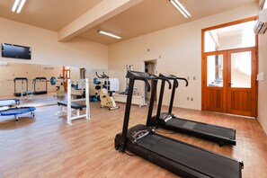Stay active with our fully equipped gym featuring treadmills, a weight bench, and a trampoline.
