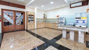 A hotel lobby with a marble floor, wooden cabinets, a reception desk, and a coffee station. - Hotel Suárez Campo Bom (Campo Bom)