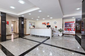 Welcome to our reception area, featuring a polished floor, a reception desk, and a staircase leading to the upper level.