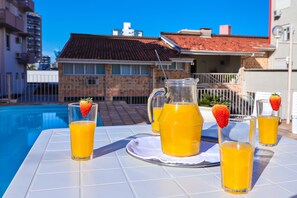 Enjoy a refreshing drink by the pool, surrounded by a tranquil atmosphere.