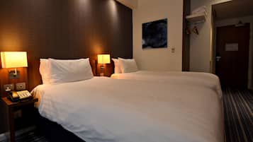 Habitación de hotel con una cama grande, dos lámparas de noche, un teléfono y un cuadro en la pared.
