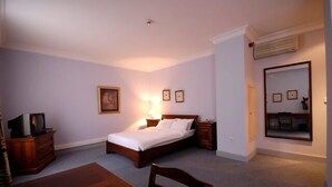 A bedroom with a bed, bedside tables, a dresser, a desk, and a chair. - The Horizon Hotel (Baku)