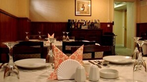 A restaurant with tables set for dining, a bar area with bottles, and a framed picture on the wall. - The Horizon Hotel (Baku)