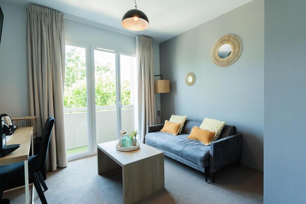 Un salon moderne comprenant un canapé, une table basse et un bureau avec une chaise.