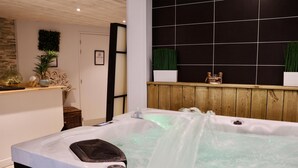 A spa area with a hot tub, wooden paneling, and a tiled wall with a grid pattern. - Best Western Hotel Garden & Spa (La Baule-Escoublac)