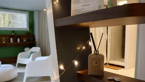 A modern interior with a wooden shelf displaying a perfume bottle, a string of lights, and a menu. - Best Western Hotel Garden & Spa (La Baule-Escoublac)