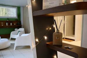 A modern interior with a wooden shelf displaying a perfume bottle, a string of lights, and a menu. - Best Western Hotel Garden & Spa (La Baule-Escoublac)