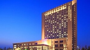 Un hotel de gran altura con varias plantas, una entrada destacada y una fachada bien iluminada.