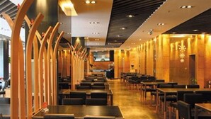 Un restaurante moderno con una barra larga y varias mesas.