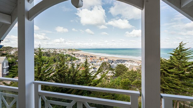 A coastal town with a beach, surrounded by greenery and residential buildings. - Les Villas du Spa (Pleneuf-Val-Andre)