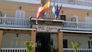 A hotel named "Hotel Chipiona" with multiple balconies, a signboard, and flags.