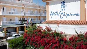 A hotel named "Hotel Chipiona" with multiple balconies and a tiled roof.