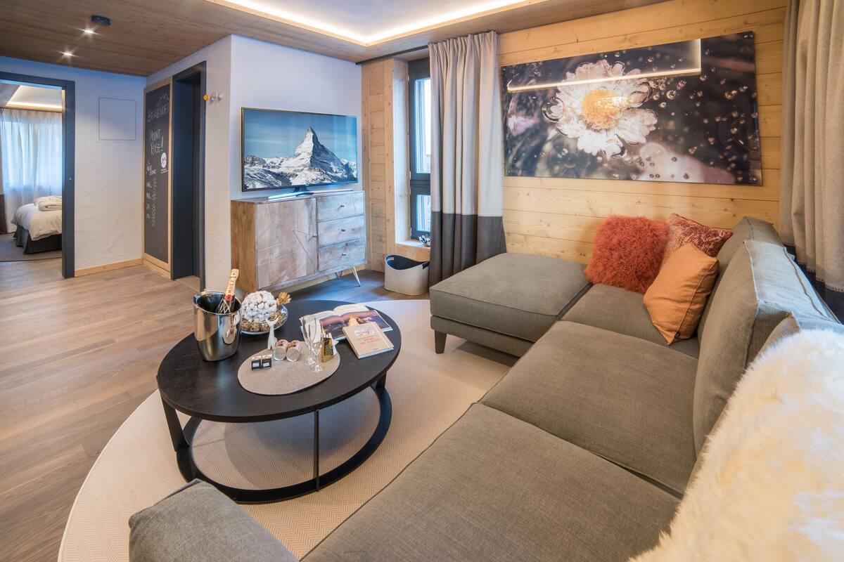 A modern living room with a sofa, a coffee table, and a painting on the wall.