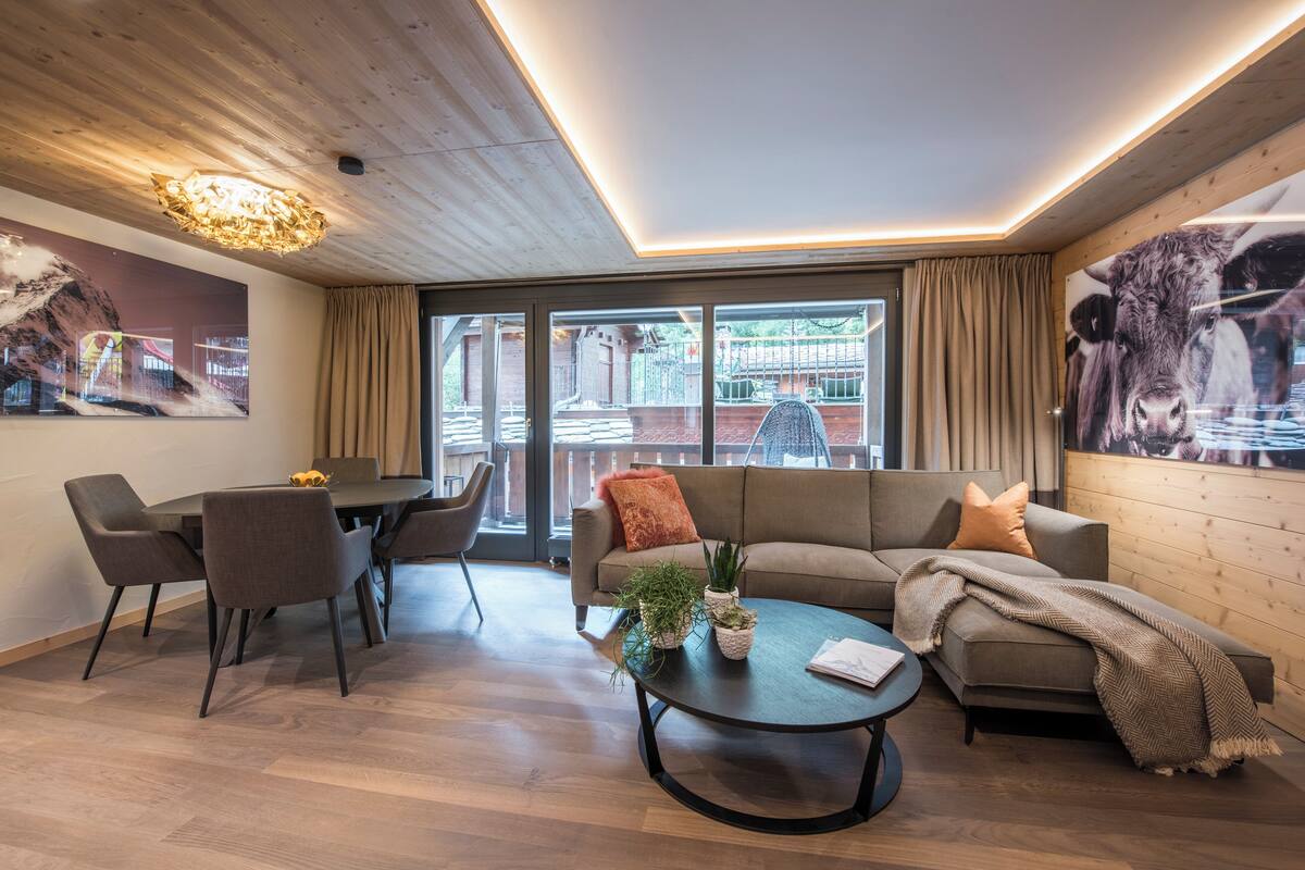 A modern living room with a sofa, coffee table, and dining area.
