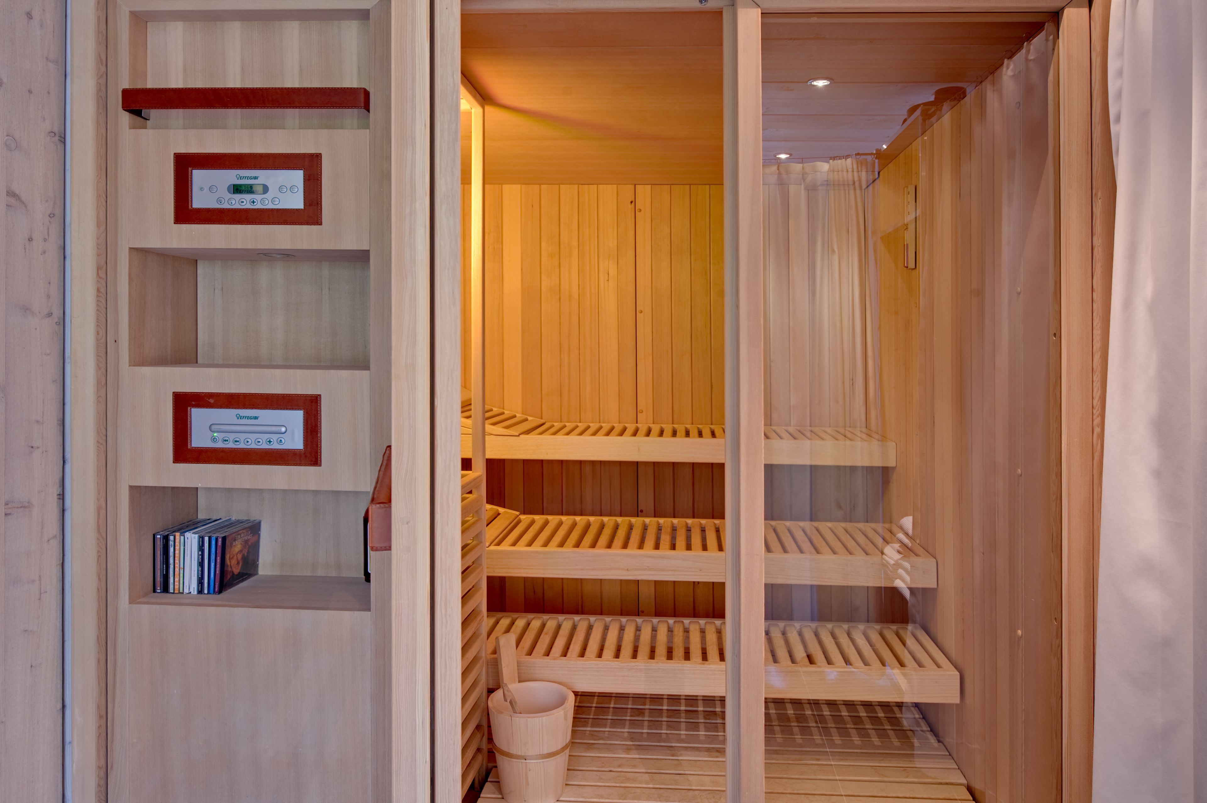 Een sauna met houten banken en een bedieningspaneel.