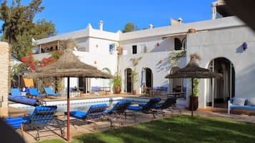 Relax by the pool surrounded by lush greenery and comfortable lounge chairs.