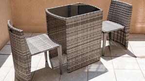 A wicker outdoor seating area with a table and two chairs. - Le 21 Hotel (Saint-Raphael)