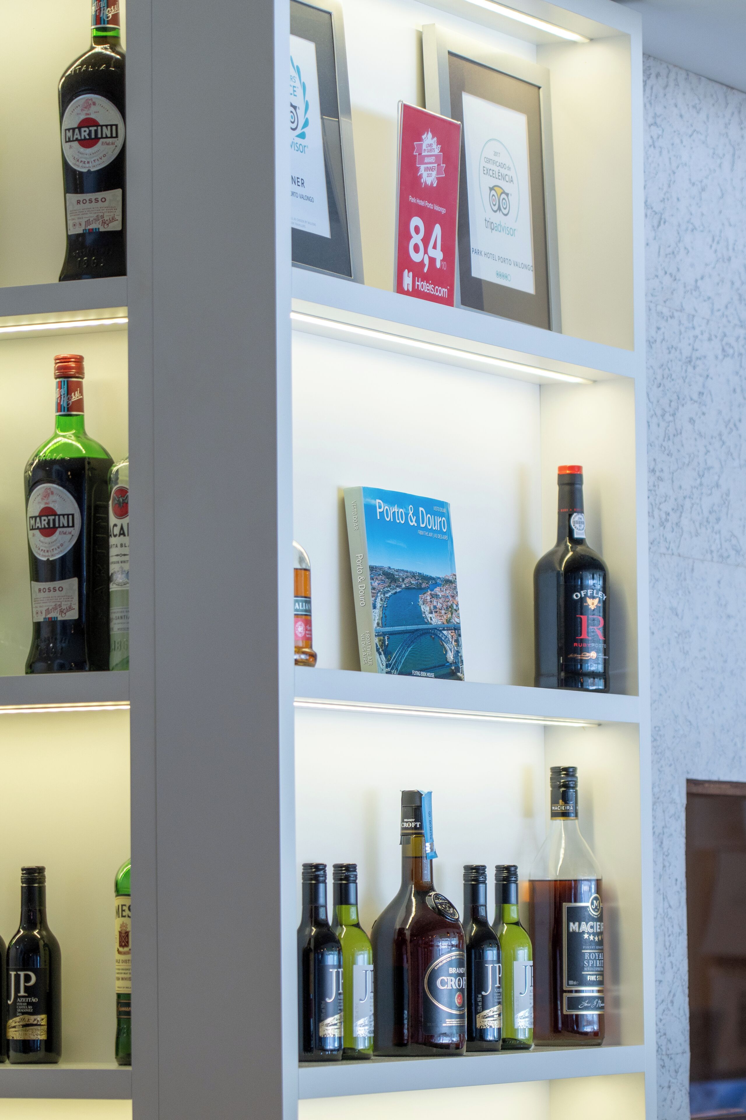 A hotel display with various liquor bottles and a framed map of Porto & Douro.