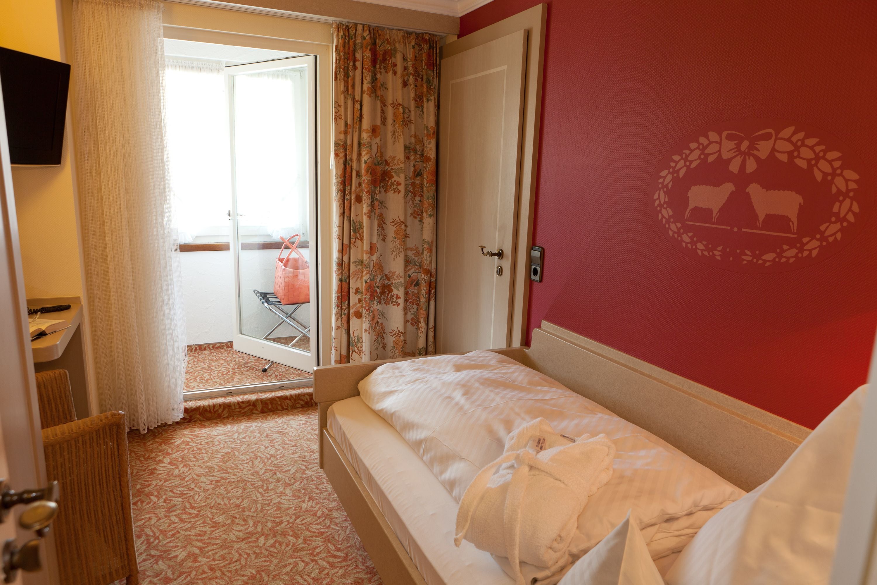 Ett hotellrum med en säng, ett badrum och utsikt över omgivningarna.