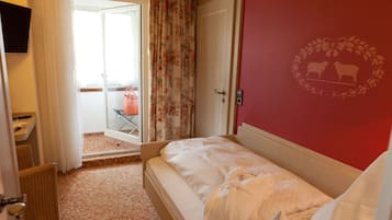A hotel room with a bed, a bathroom, and a view of the outside.
