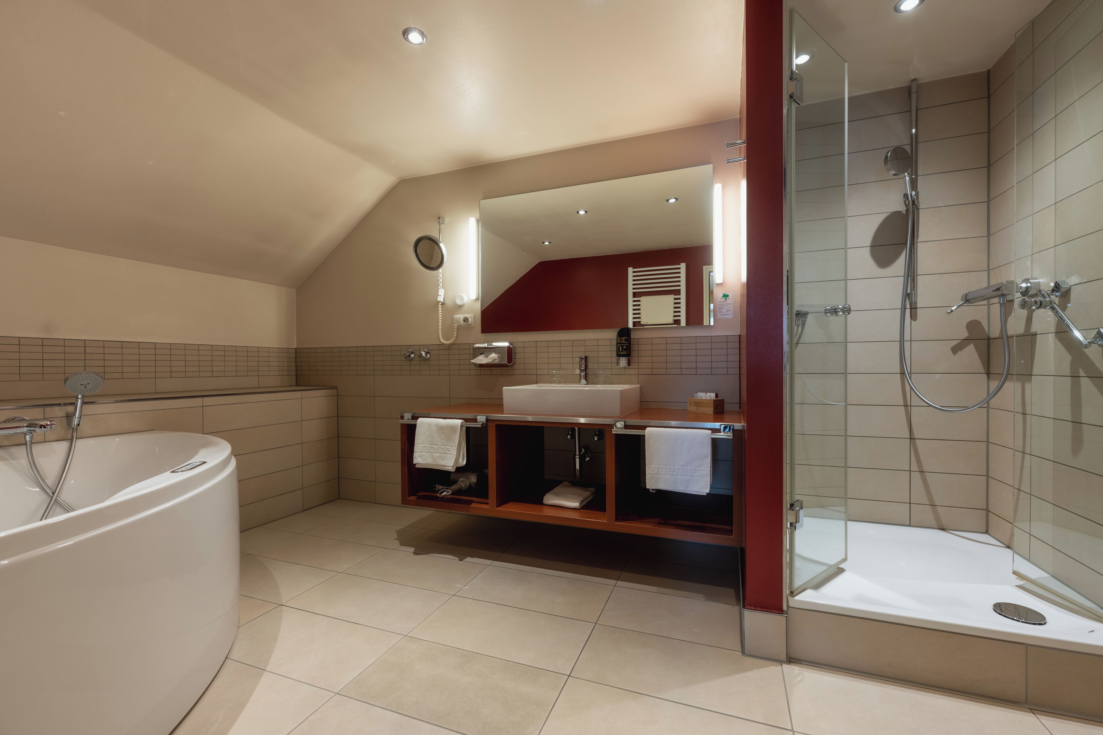 A modern bathroom with a freestanding bathtub, a glass-enclosed shower, and a vanity with a mirror.