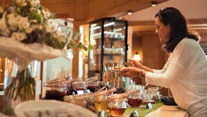 Ein reichhaltiges Buffet mit verschiedenen Speisen und einer Person, die etwas serviert.