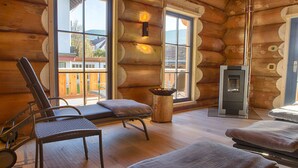 Eine Blockhütte mit Sauna, Holzböden und großen Fenstern.