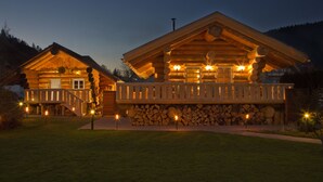 Eine Blockhütte mit Balkon und Steinfundament.