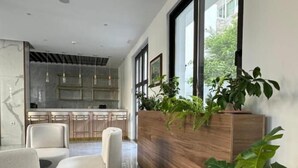 Un intérieur moderne comprenant une cuisine, un coin salon et de grandes fenêtres.