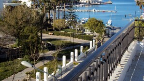 Un port de plaisance situé sur la côte, avec des bateaux, des palmiers et des bâtiments en arrière-plan.